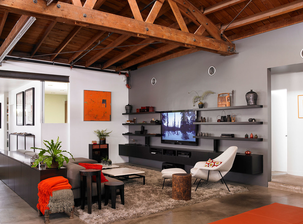 Imagen de salón tipo loft moderno grande sin chimenea con paredes grises y televisor colgado en la pared