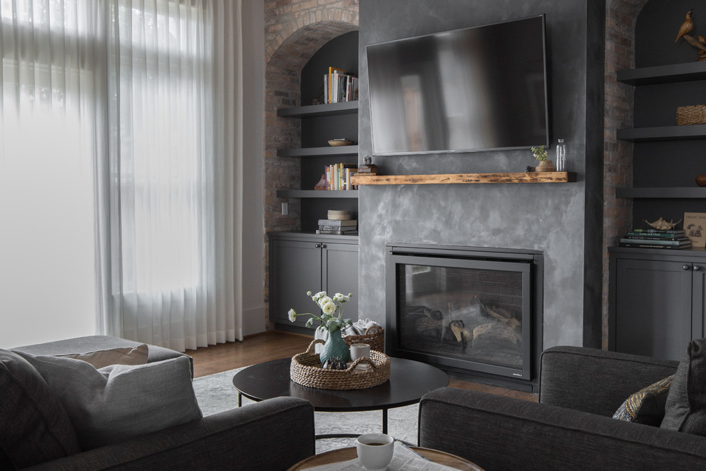 Cette photo montre un salon éclectique avec un mur blanc, un sol en bois brun, une cheminée standard et un manteau de cheminée en plâtre.
