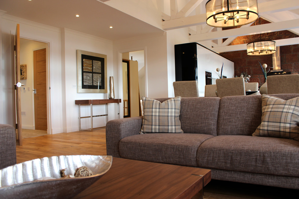 Foto di un soggiorno classico aperto con parquet chiaro e TV a parete