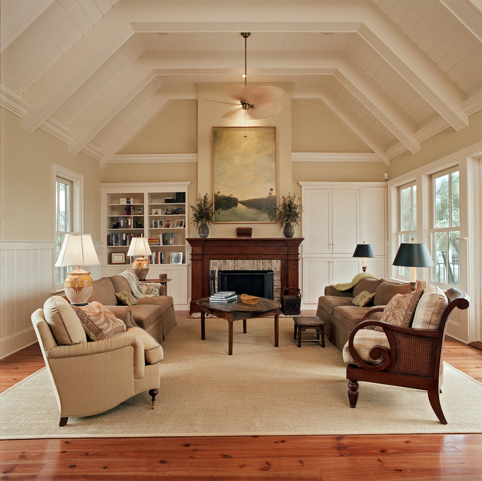 Repräsentatives, Fernseherloses, Großes, Abgetrenntes Klassisches Wohnzimmer mit beiger Wandfarbe, braunem Holzboden, Kamin und Kaminumrandung aus Backstein in Charleston