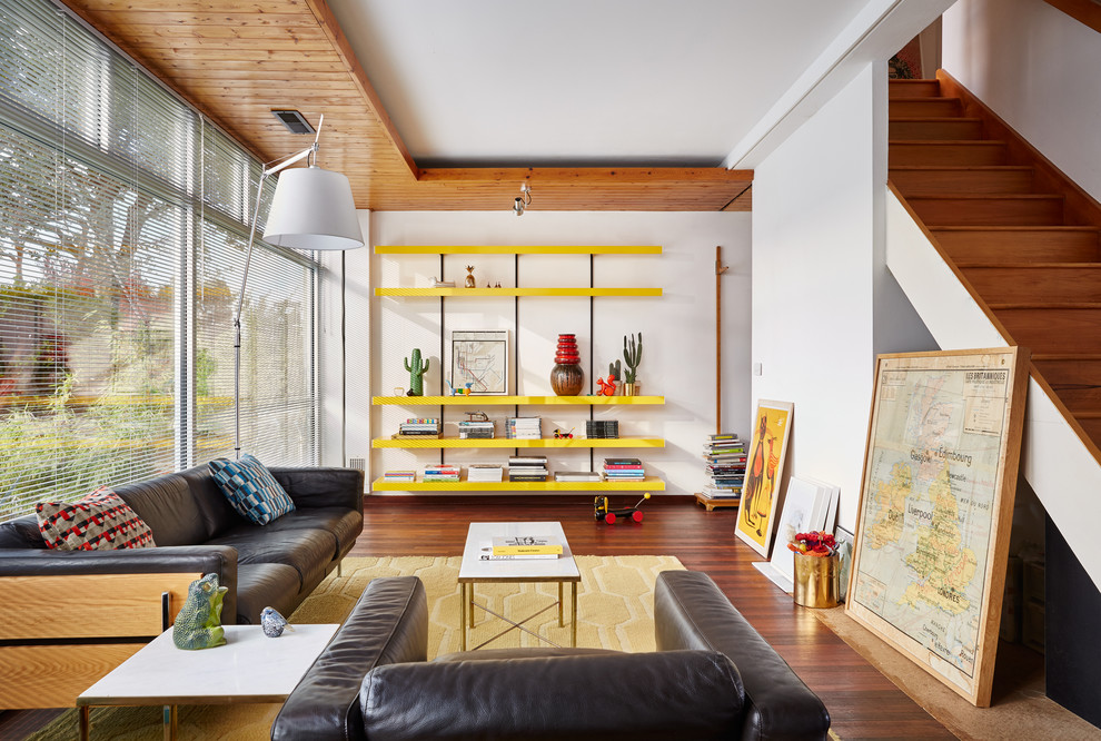 Inspiration pour un salon design ouvert avec un mur blanc et un sol en bois brun.