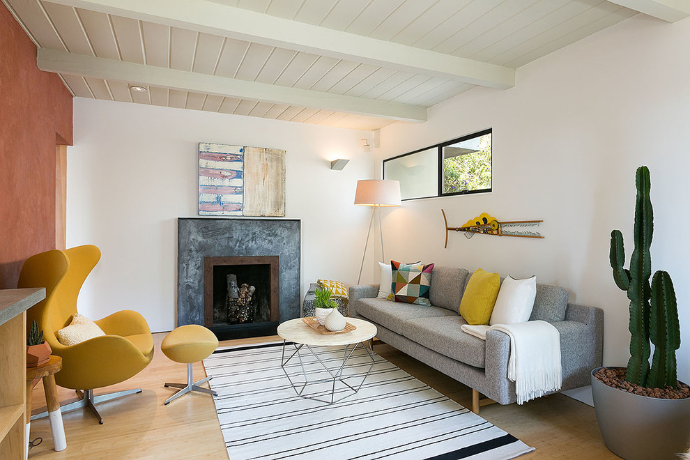 Cette image montre un salon vintage avec un mur blanc, une cheminée standard, un sol beige et éclairage.