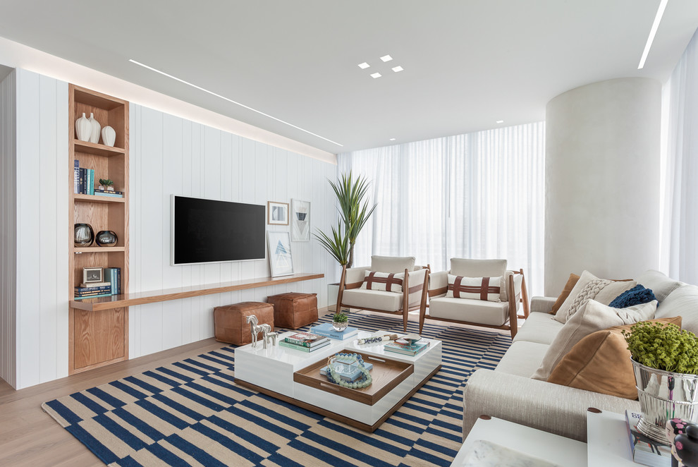 Diseño de salón abierto costero grande con paredes blancas, suelo de baldosas de porcelana y televisor colgado en la pared