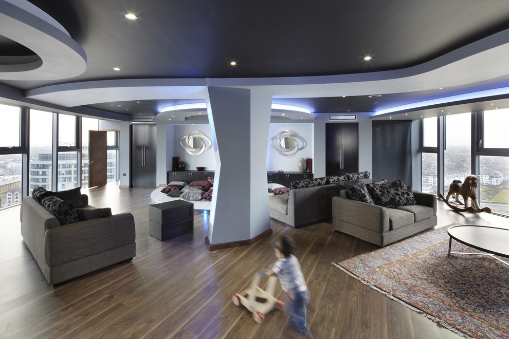 Пример оригинального дизайна: открытая гостиная комната в современном стиле с серыми стенами и коричневым полом