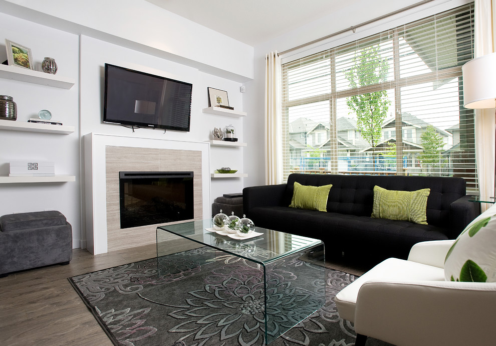 Mittelgroßes, Offenes Modernes Wohnzimmer mit grauer Wandfarbe, braunem Holzboden, Kamin, gefliester Kaminumrandung und TV-Wand in Vancouver