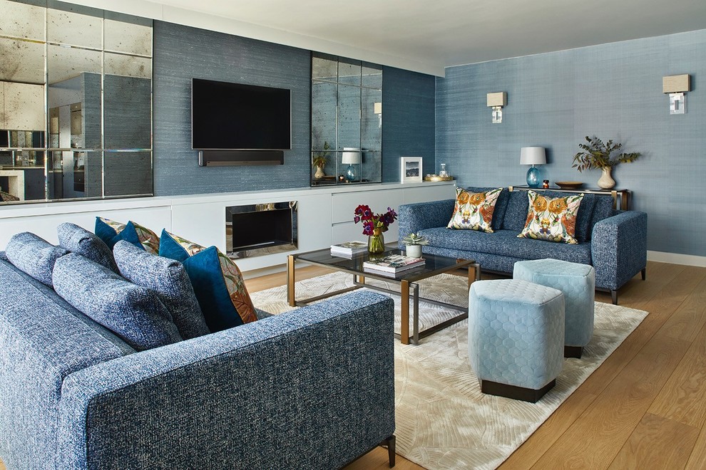 Réalisation d'un salon design avec un mur bleu, un sol en bois brun, une cheminée standard, un téléviseur fixé au mur et un sol marron.
