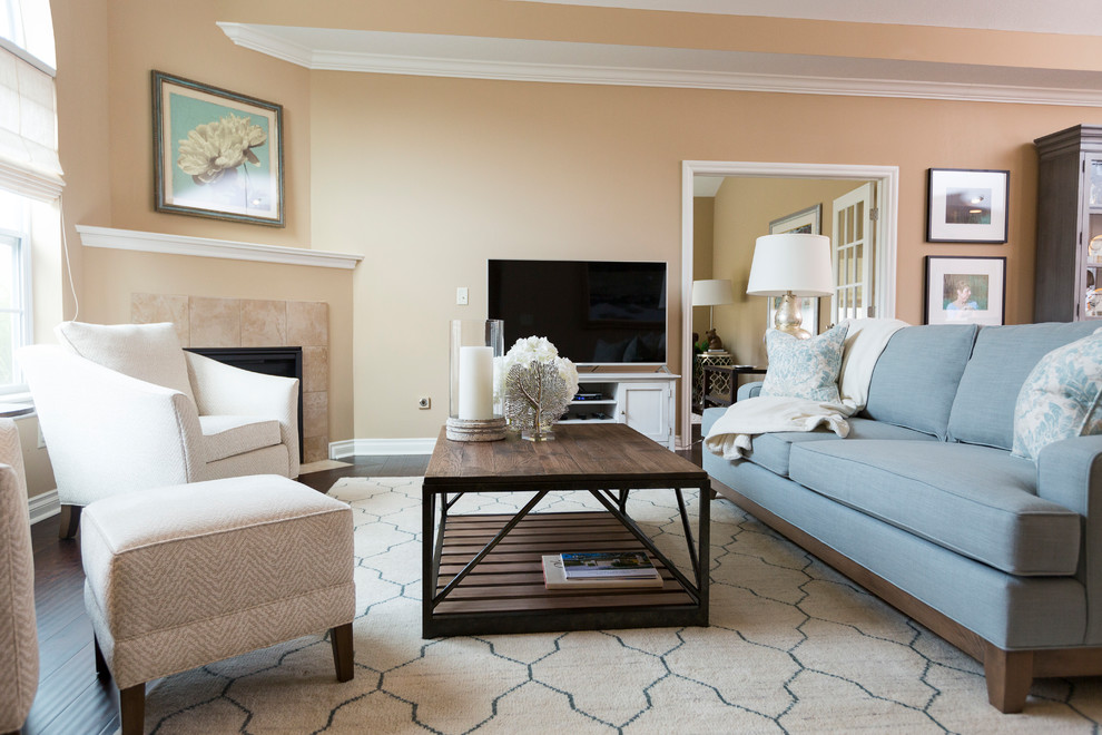 Medium sized traditional open plan living room in Cincinnati with beige walls, dark hardwood flooring, a freestanding tv and a corner fireplace.