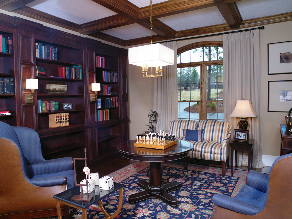 Foto de biblioteca en casa abierta clásica de tamaño medio sin chimenea y televisor con paredes beige y suelo de madera en tonos medios