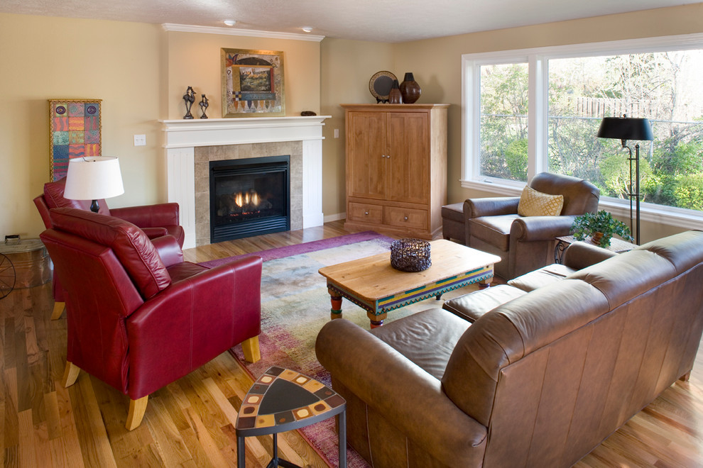 Mittelgroßes, Fernseherloses, Offenes Klassisches Wohnzimmer mit gelber Wandfarbe, braunem Holzboden, Kamin und gefliester Kaminumrandung in Boise