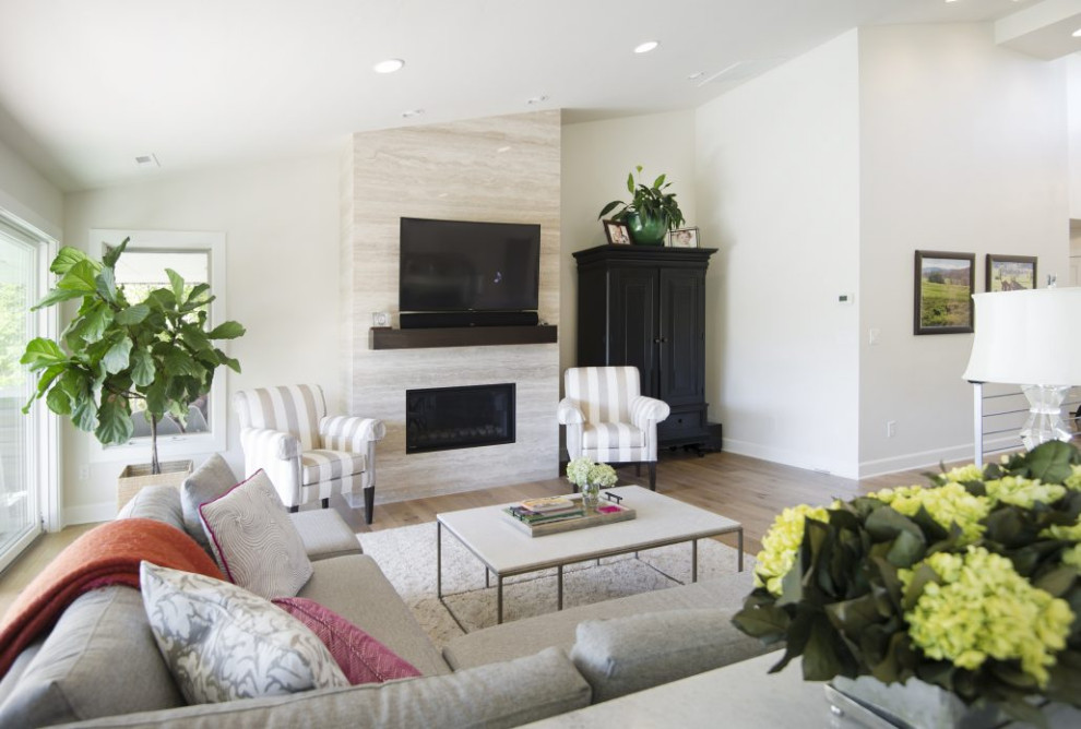 Mittelgroßes, Offenes Modernes Wohnzimmer mit weißer Wandfarbe, hellem Holzboden, Kamin, Kaminumrandung aus Stein, TV-Wand und braunem Boden in Boise