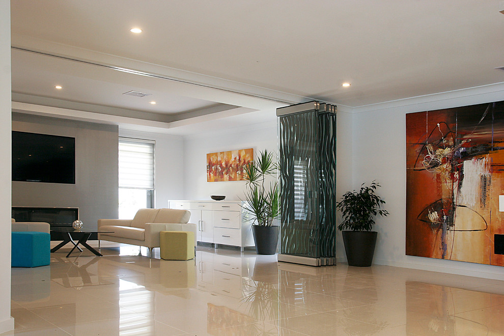 Свежая идея для дизайна: большая парадная, изолированная гостиная комната в стиле модернизм с белыми стенами, полом из керамогранита, стандартным камином, фасадом камина из бетона, телевизором на стене и белым полом - отличное фото интерьера