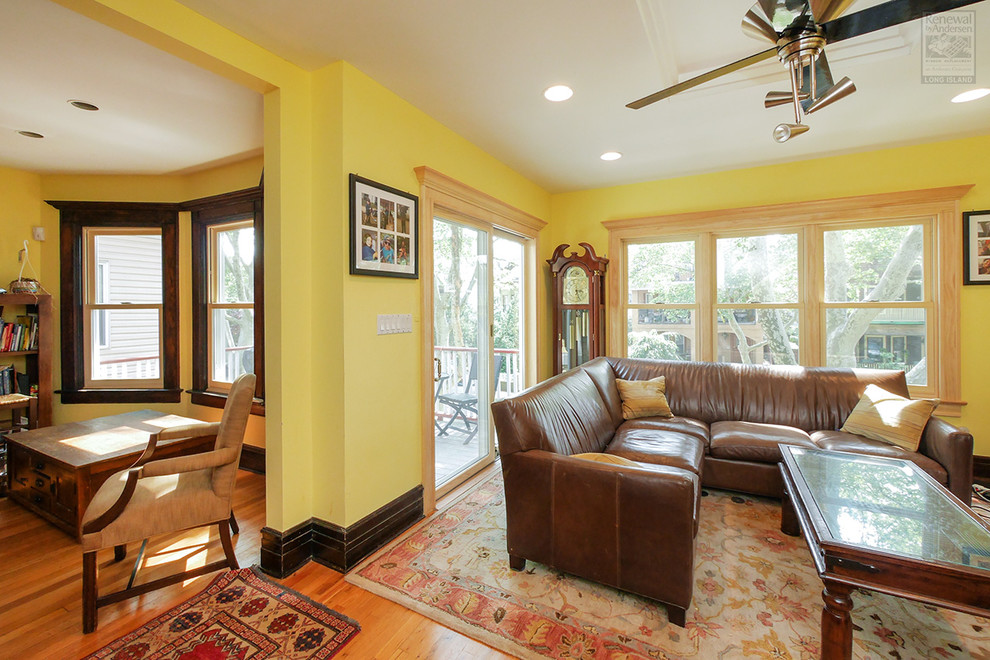 Exemple d'un salon de taille moyenne et ouvert avec un mur jaune, un sol en bois brun et un sol multicolore.