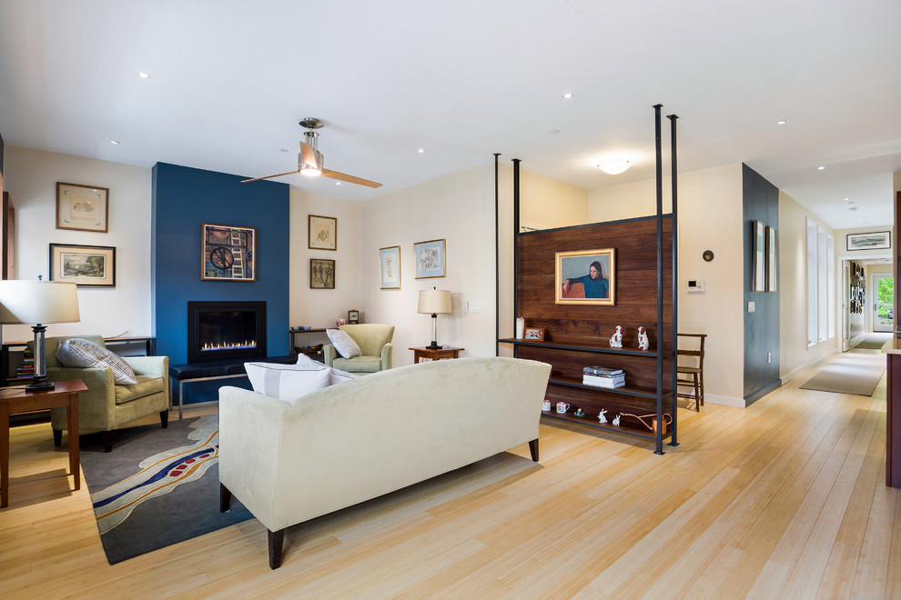 Пример оригинального дизайна: открытая, парадная гостиная комната среднего размера в стиле модернизм с полом из бамбука, стандартным камином, бежевыми стенами, фасадом камина из металла и бежевым полом без телевизора