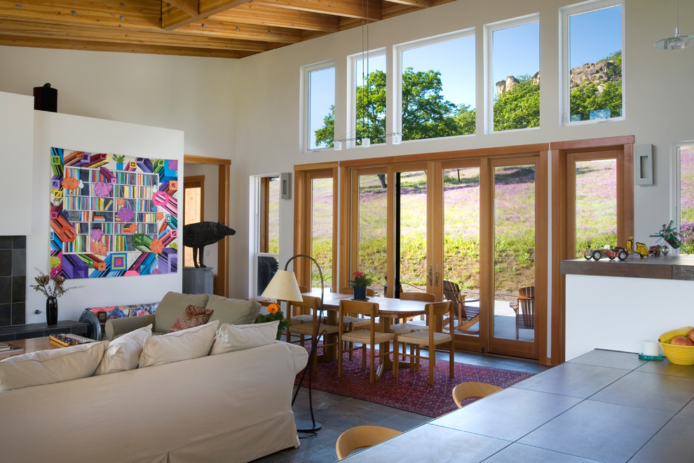 Offenes, Großes Modernes Wohnzimmer mit weißer Wandfarbe, Kamin, gefliester Kaminumrandung, buntem Boden und Terrakottaboden in Sonstige