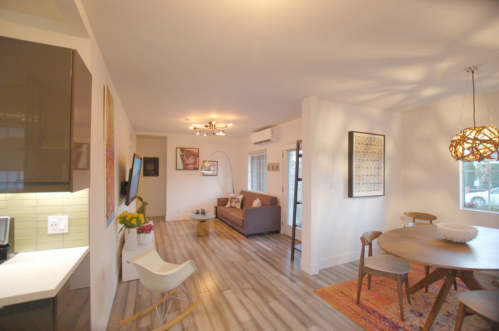 Свежая идея для дизайна: двухуровневая гостиная комната среднего размера в современном стиле с белыми стенами, полом из бамбука, телевизором на стене и серым полом - отличное фото интерьера