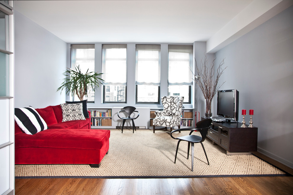 Foto di un grande soggiorno design stile loft con TV autoportante, pareti grigie e pavimento in legno massello medio