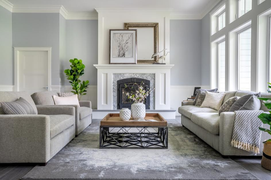 バンクーバーにある高級な中くらいなトラディショナルスタイルのおしゃれなリビング (白い壁、ラミネートの床、標準型暖炉、タイルの暖炉まわり、テレビなし、グレーの床) の写真