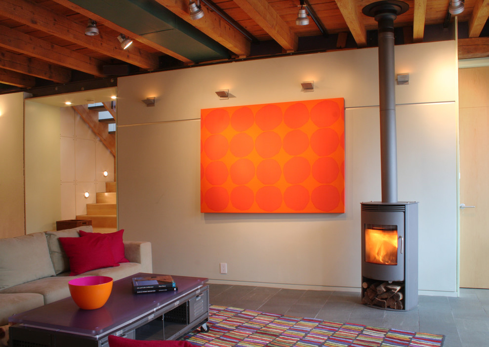 Пример оригинального дизайна: гостиная комната в стиле лофт с бежевыми стенами и печью-буржуйкой