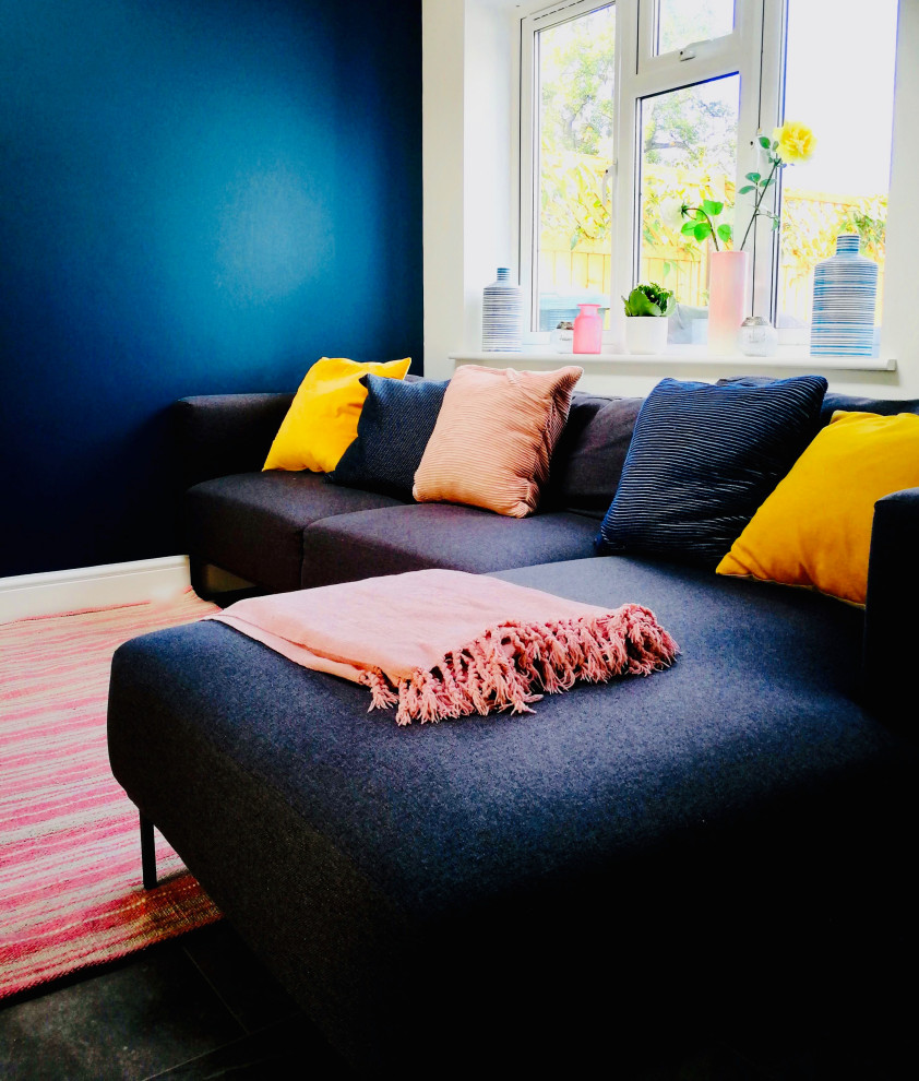 Modelo de salón abierto moderno de tamaño medio con paredes azules, suelo de pizarra y suelo gris