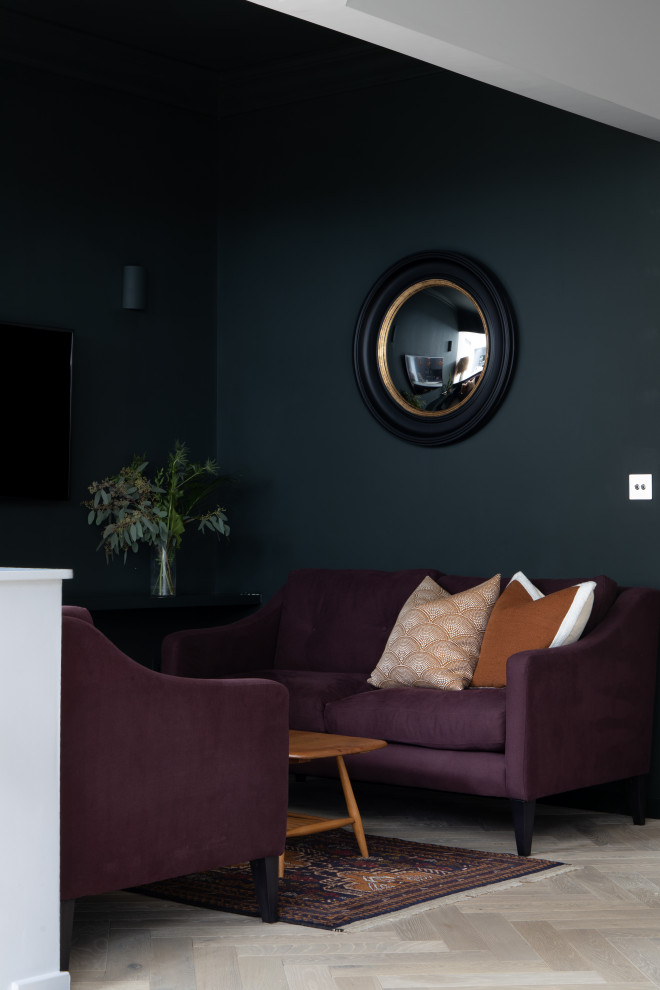 This is an example of a medium sized scandinavian enclosed living room in Other with green walls, light hardwood flooring and a wall mounted tv.