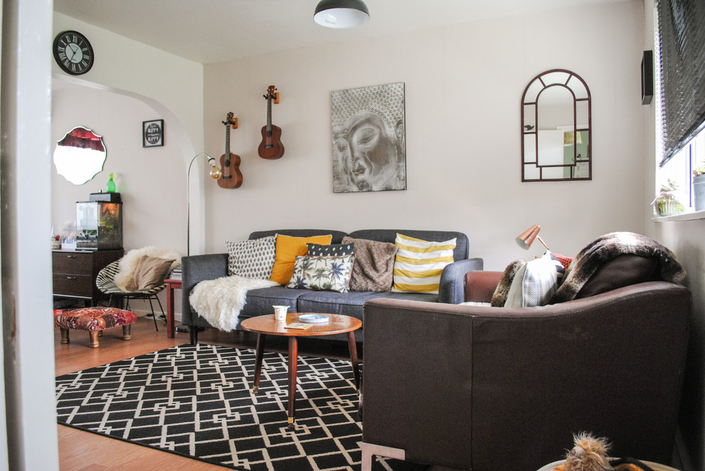Esempio di un soggiorno eclettico di medie dimensioni e chiuso con pareti bianche, pavimento in legno massello medio e pavimento marrone