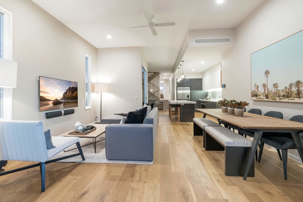 Photo of a medium sized modern open plan living room in Gold Coast - Tweed with white walls, light hardwood flooring, no fireplace, a wall mounted tv and brown floors.