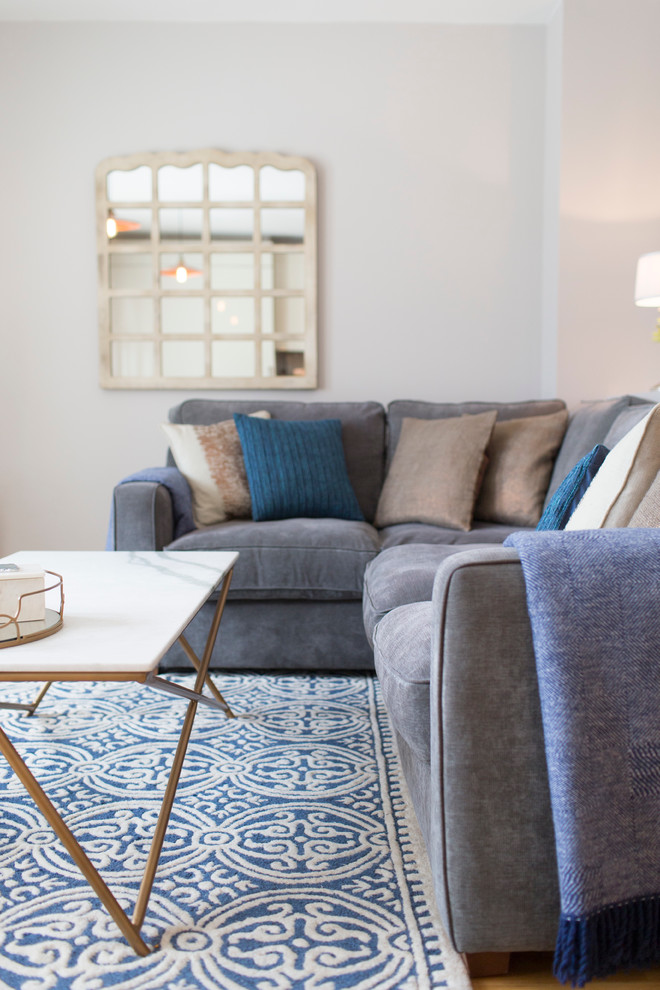 Kleines, Offenes Eklektisches Wohnzimmer ohne Kamin mit grauer Wandfarbe, hellem Holzboden und freistehendem TV in London