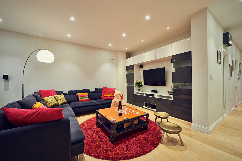 Идея дизайна: открытая гостиная комната среднего размера в современном стиле с телевизором на стене, светлым паркетным полом, белыми стенами и ковром на полу без камина