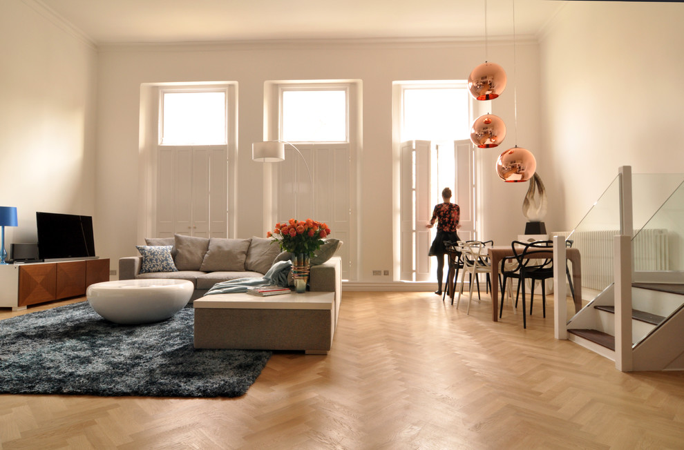 Стильный дизайн: гостиная комната в современном стиле с белыми стенами и ковром на полу - последний тренд