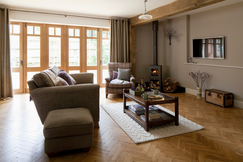 Aménagement d'un salon craftsman ouvert avec un sol en bois brun et un poêle à bois.