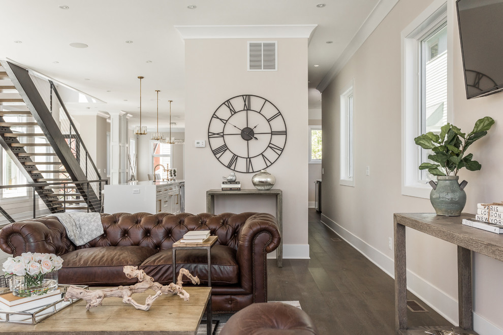 Esempio di un ampio soggiorno chic aperto con pareti beige, parquet scuro, TV a parete e pavimento marrone