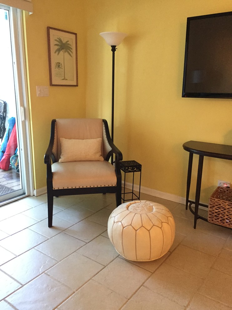 マイアミにある広いトラディショナルスタイルのおしゃれな独立型リビング (黄色い壁、セラミックタイルの床、暖炉なし、壁掛け型テレビ) の写真