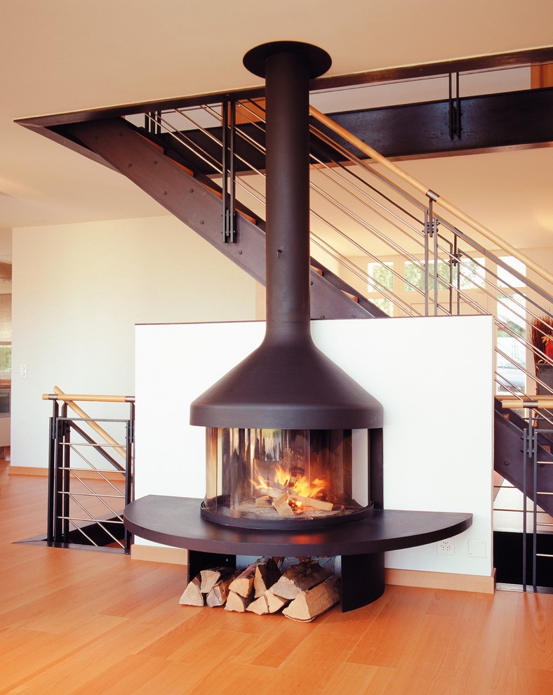 Contemporary living room in Devon with medium hardwood flooring and a wood burning stove.