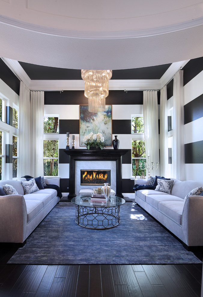 Идея дизайна: парадная, открытая гостиная комната среднего размера в стиле неоклассика (современная классика) с черными стенами, темным паркетным полом, стандартным камином, фасадом камина из плитки и коричневым полом без телевизора