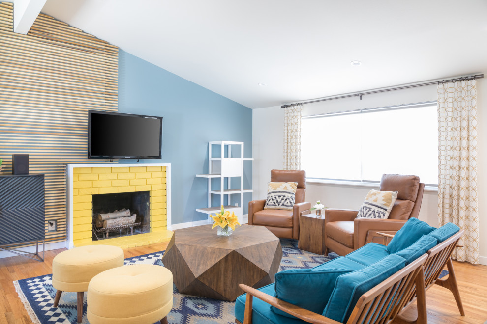 Inspiration for a small contemporary open plan living room in Orange County with blue walls, medium hardwood flooring, a standard fireplace, a brick fireplace surround and brown floors.