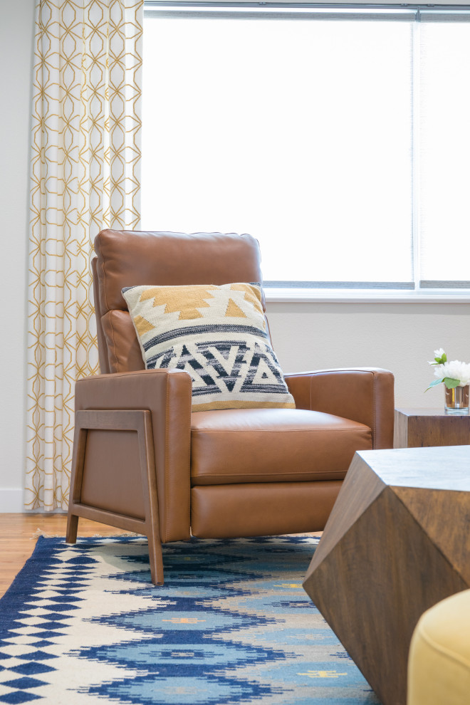 Immagine di un piccolo soggiorno minimalista aperto con pareti blu, pavimento in legno massello medio, camino classico, cornice del camino in mattoni e pavimento marrone