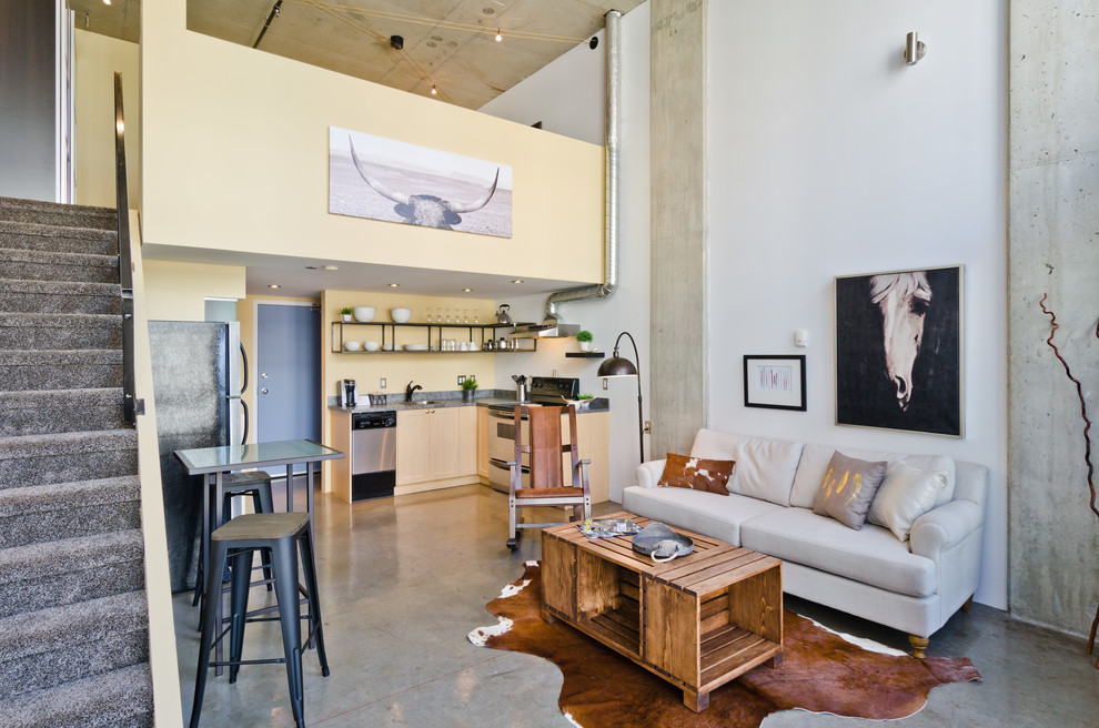 Kleines Industrial Wohnzimmer im Loft-Stil mit beiger Wandfarbe und Betonboden in Calgary