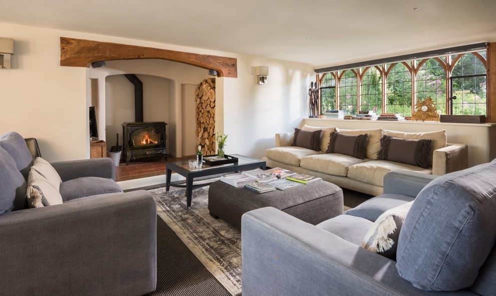 Photo of a medium sized farmhouse living room in Dorset with white walls and a wood burning stove.