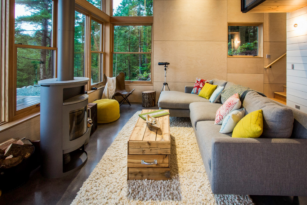 Esempio di un soggiorno rustico di medie dimensioni con sala formale, pavimento in cemento, stufa a legna, pareti beige, cornice del camino in metallo e nessuna TV