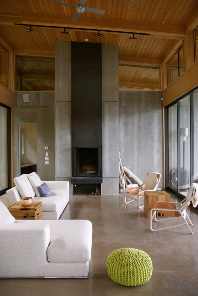 Modernes Wohnzimmer mit Kaminumrandung aus Beton und Betonboden in Seattle