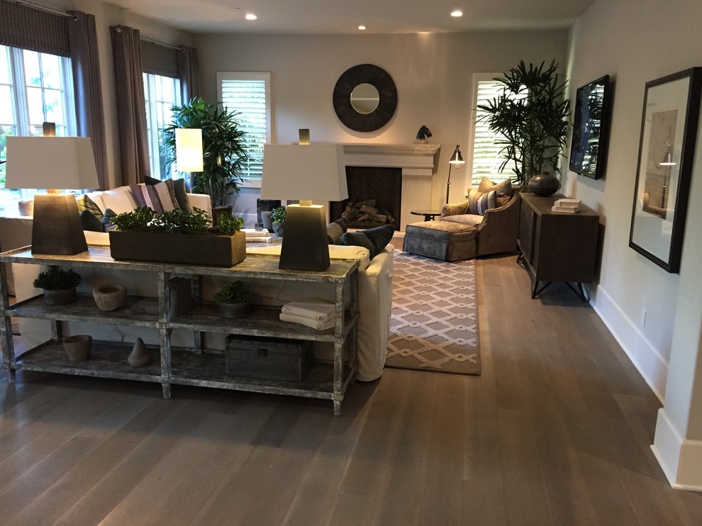 Großes, Offenes Klassisches Wohnzimmer mit beiger Wandfarbe, braunem Holzboden, Kamin, Kaminumrandung aus Stein und TV-Wand in Orange County
