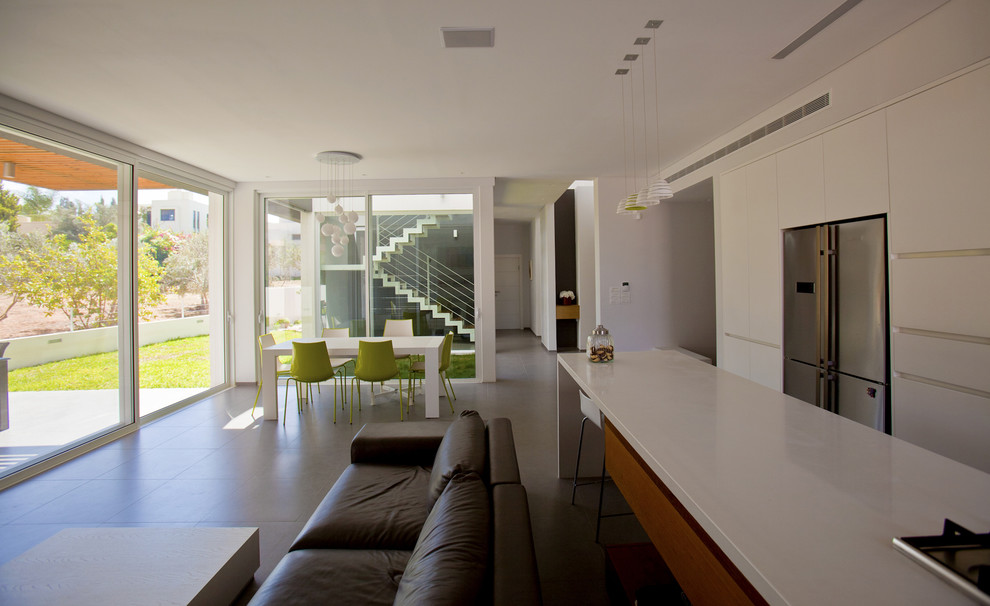 На фото: открытая гостиная комната в стиле модернизм с белыми стенами с
