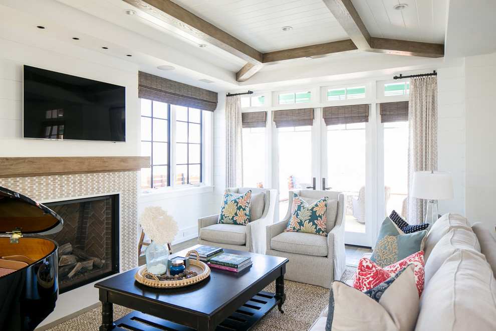 Großes, Offenes Wohnzimmer mit weißer Wandfarbe, braunem Holzboden, Kamin, gefliester Kaminumrandung, TV-Wand und braunem Boden in Orange County