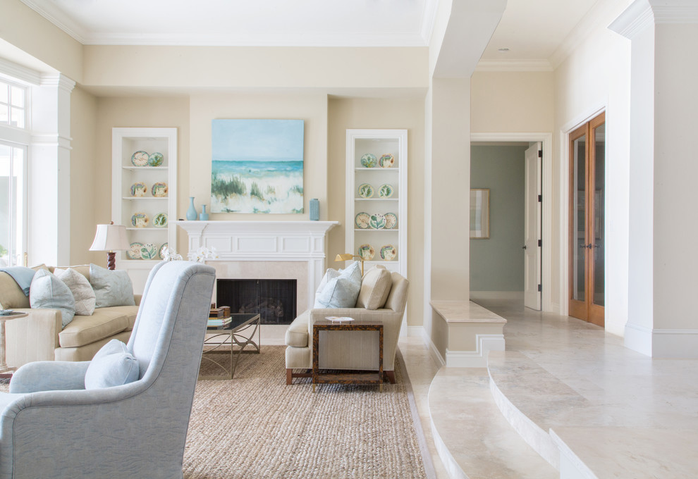 Idée de décoration pour un grand salon marin ouvert avec un mur beige, un sol en marbre, une cheminée standard, un manteau de cheminée en pierre, aucun téléviseur, une salle de réception et un sol gris.