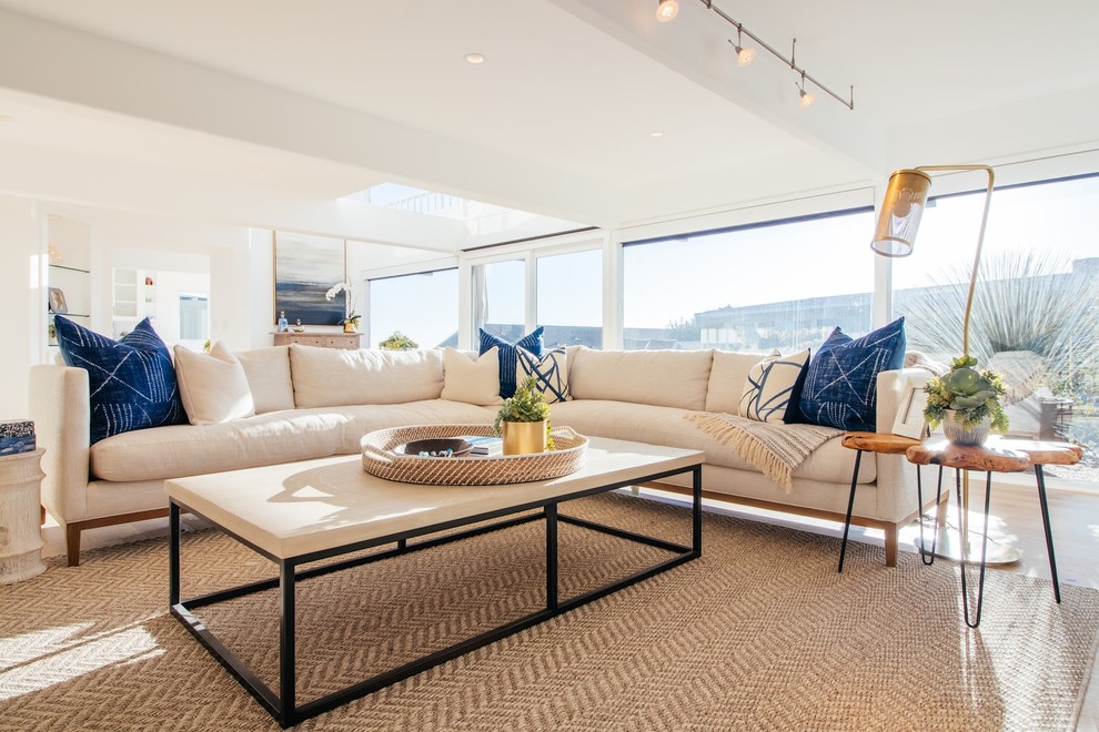 Foto di un grande soggiorno stile marino aperto con sala formale, pareti bianche, parquet chiaro, nessun camino, nessuna TV e pavimento marrone