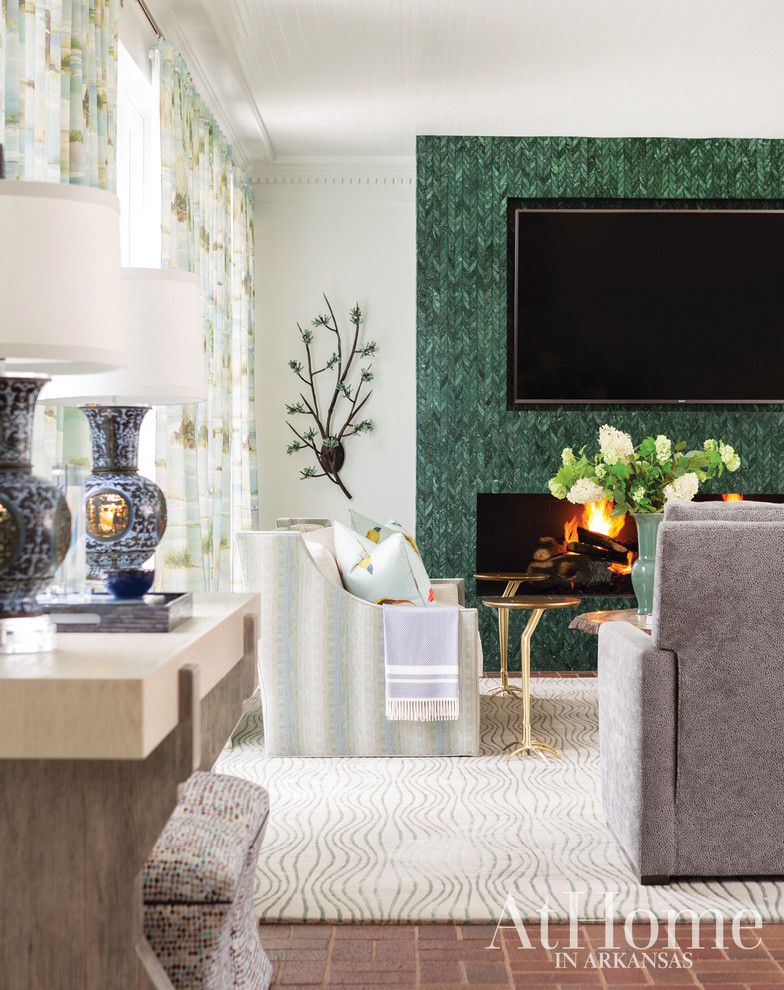 Стильный дизайн: гостиная комната в стиле фьюжн с кирпичным полом, стандартным камином и фасадом камина из плитки - последний тренд