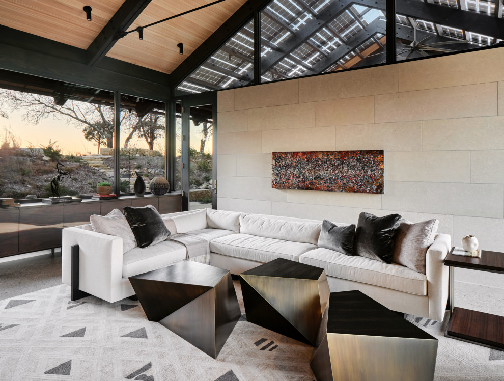 Mittelgroßes, Offenes Modernes Wohnzimmer mit beiger Wandfarbe, Betonboden, Kamin, Kaminumrandung aus Stein, grauem Boden und Holzdecke in Austin