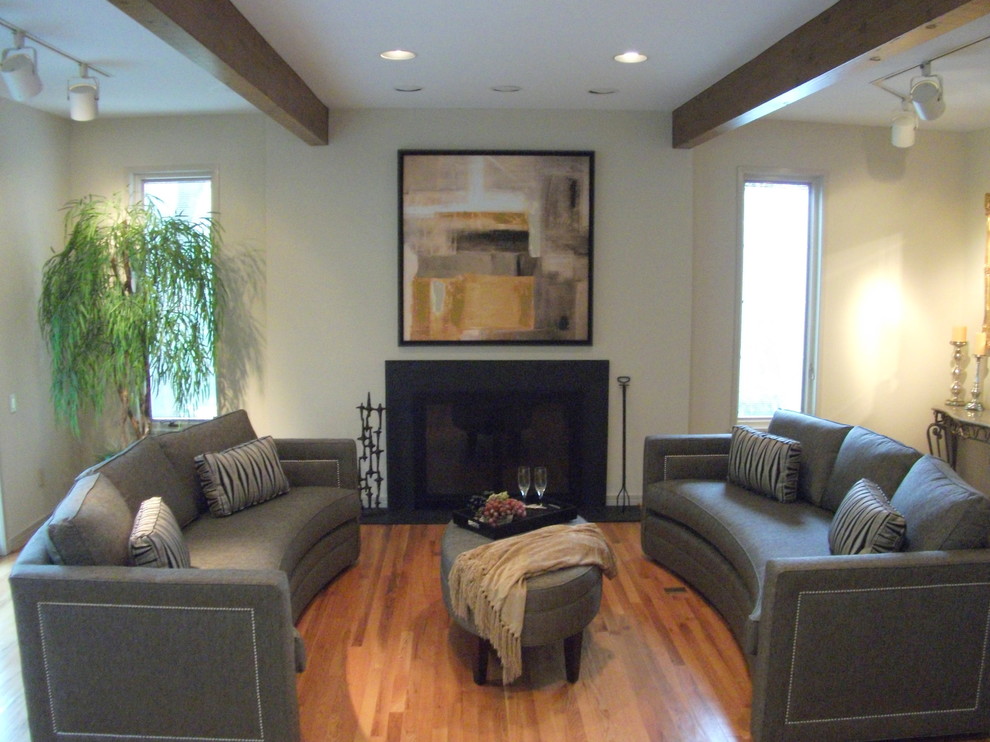 Foto di un soggiorno moderno con sala formale, pareti bianche, pavimento in legno massello medio, camino classico e cornice del camino in metallo