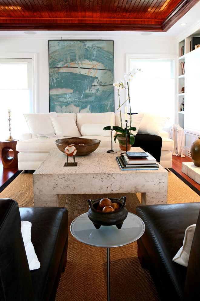 Immagine di un soggiorno classico con pareti bianche, pavimento in legno massello medio, cornice del camino in legno e TV nascosta