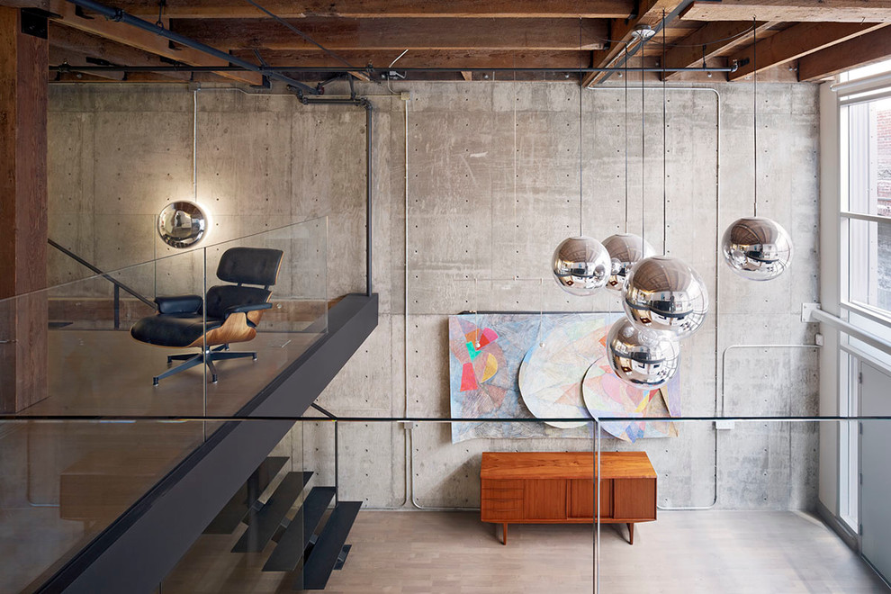 Bild på ett litet industriellt vardagsrum, med grå väggar och ljust trägolv